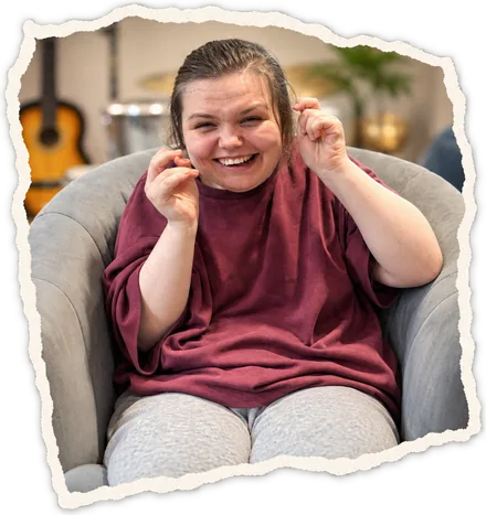 A young woman laughing in an armchair