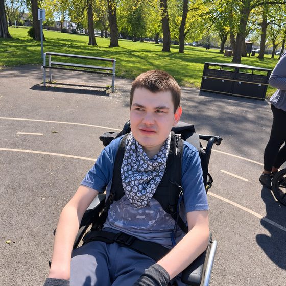 A member smiling outdoors in the park during a respite session.